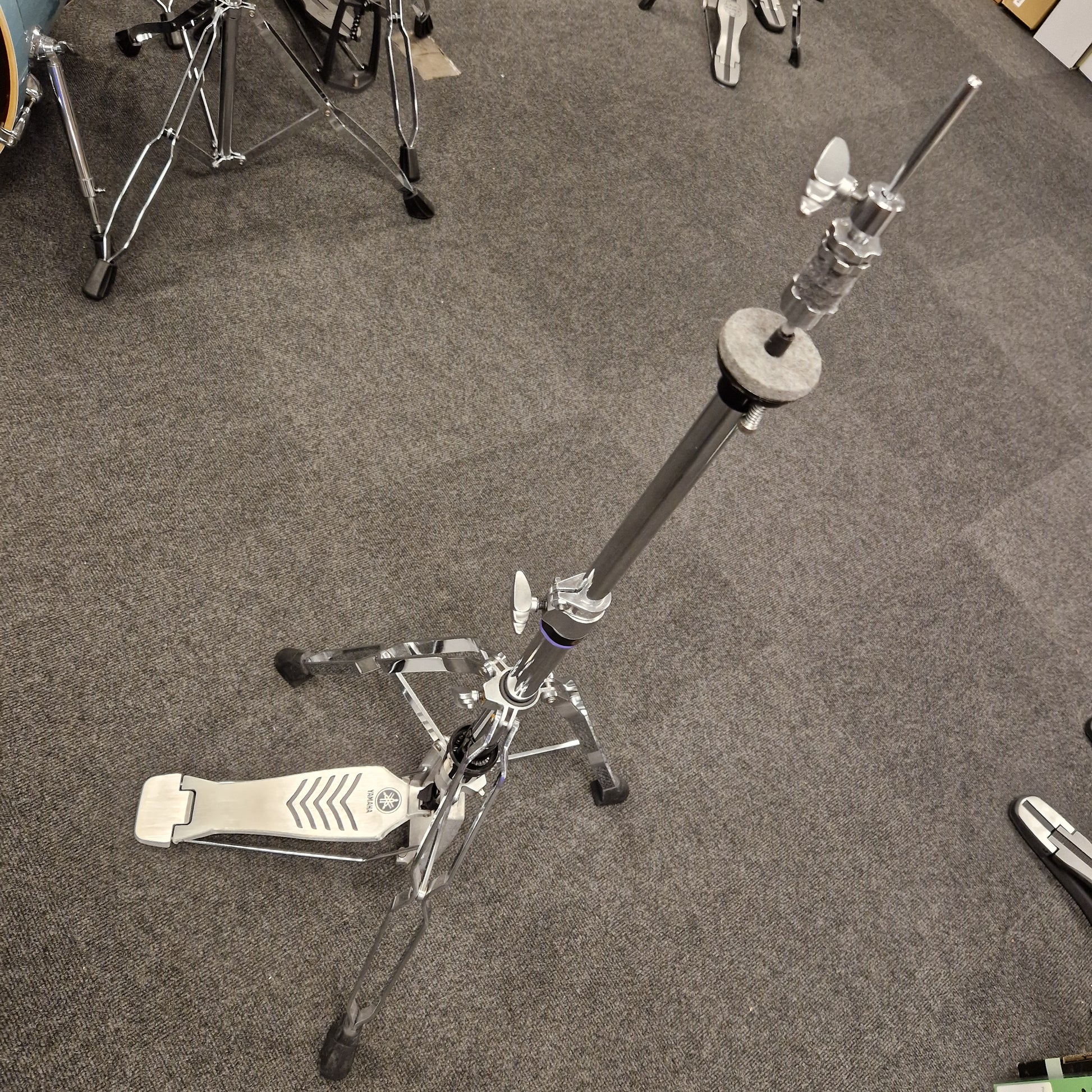 Pre-Owned Yamaha Drum stand on a gray floor with partial view of drums