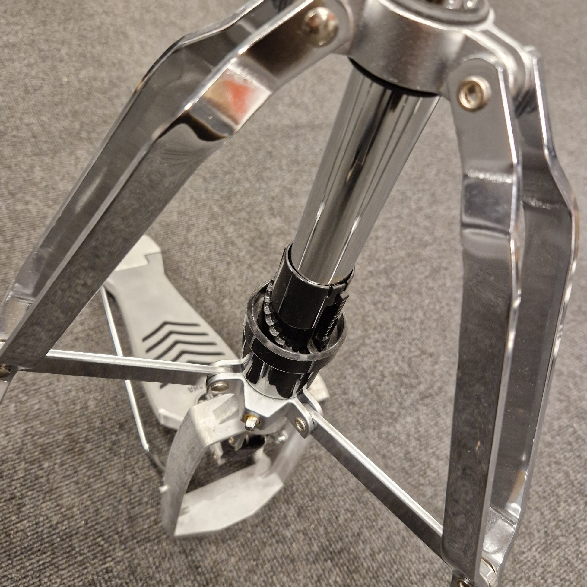 Pre-Owned Yamaha Close-up of a metal tripod stand on a textured surface