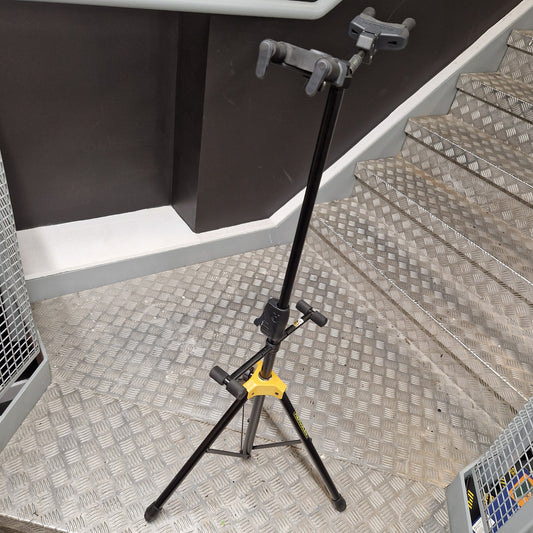Pre-Owned Hercules Black tripod with a yellow foot on a metal staircase