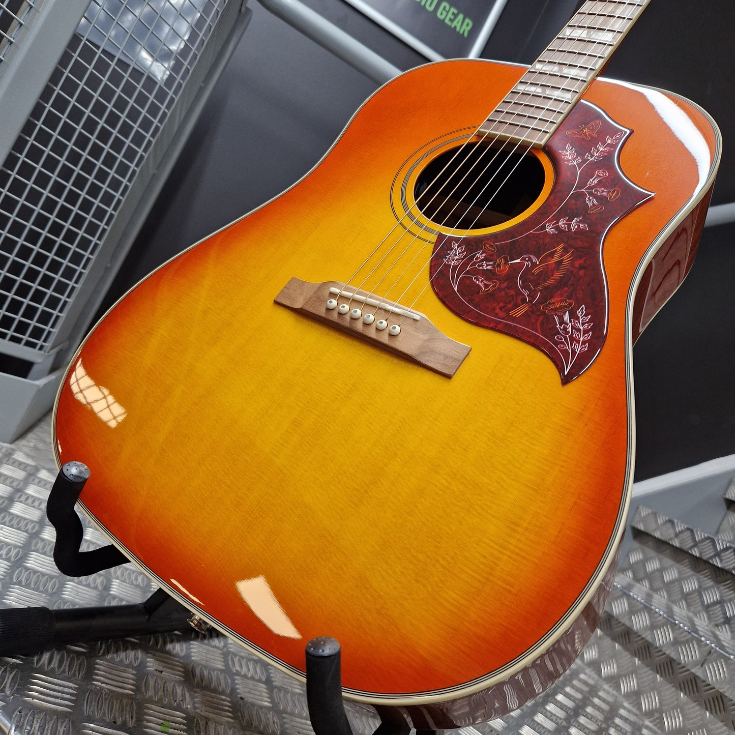 Pre-Owned Epiphone Acoustic guitar on a stand with a blurred background