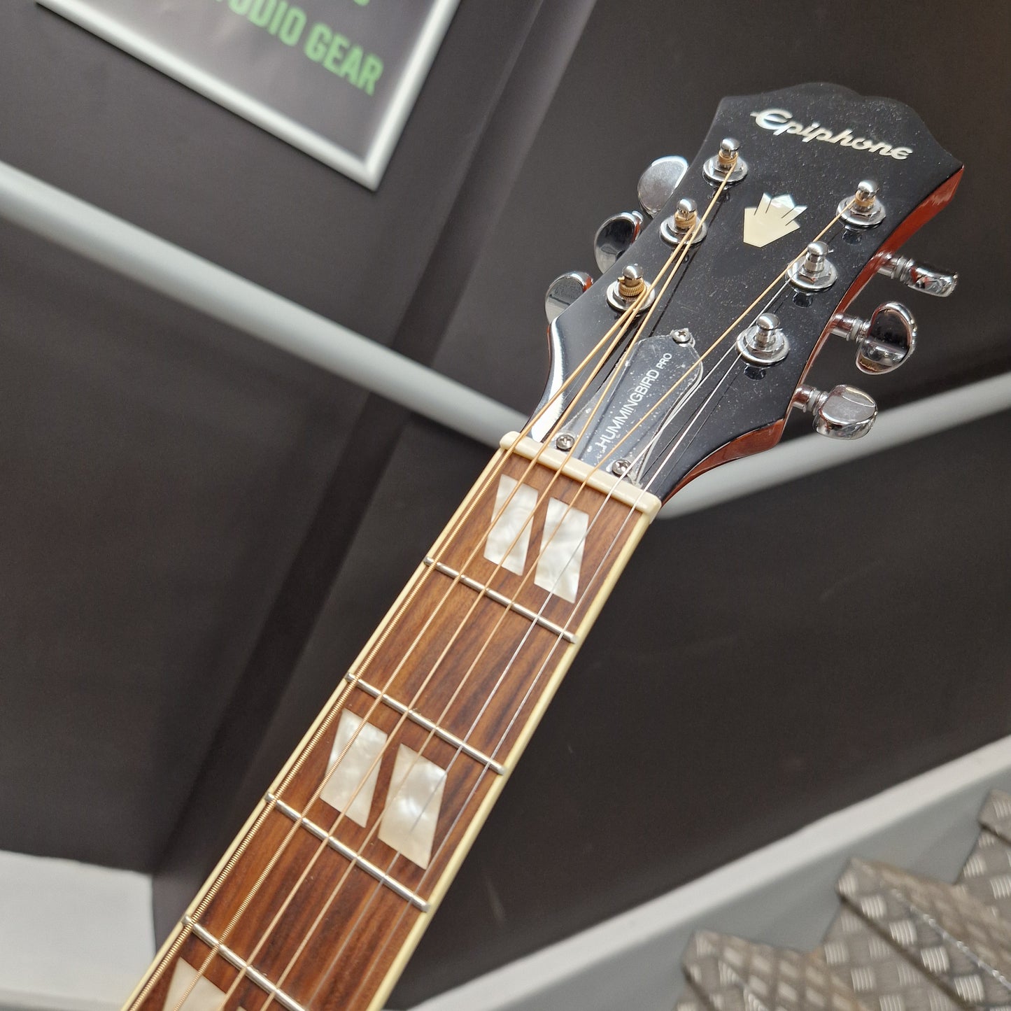 Pre-Owned Epiphone Close-up of a guitar headstock with brand name on a blurred background