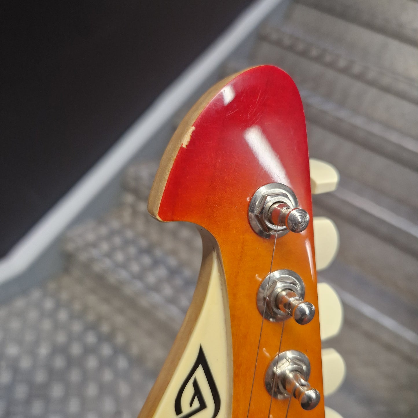Pre-Owned Lag Close-up of a guitar headstock with a red pickguard and visible brand logo.