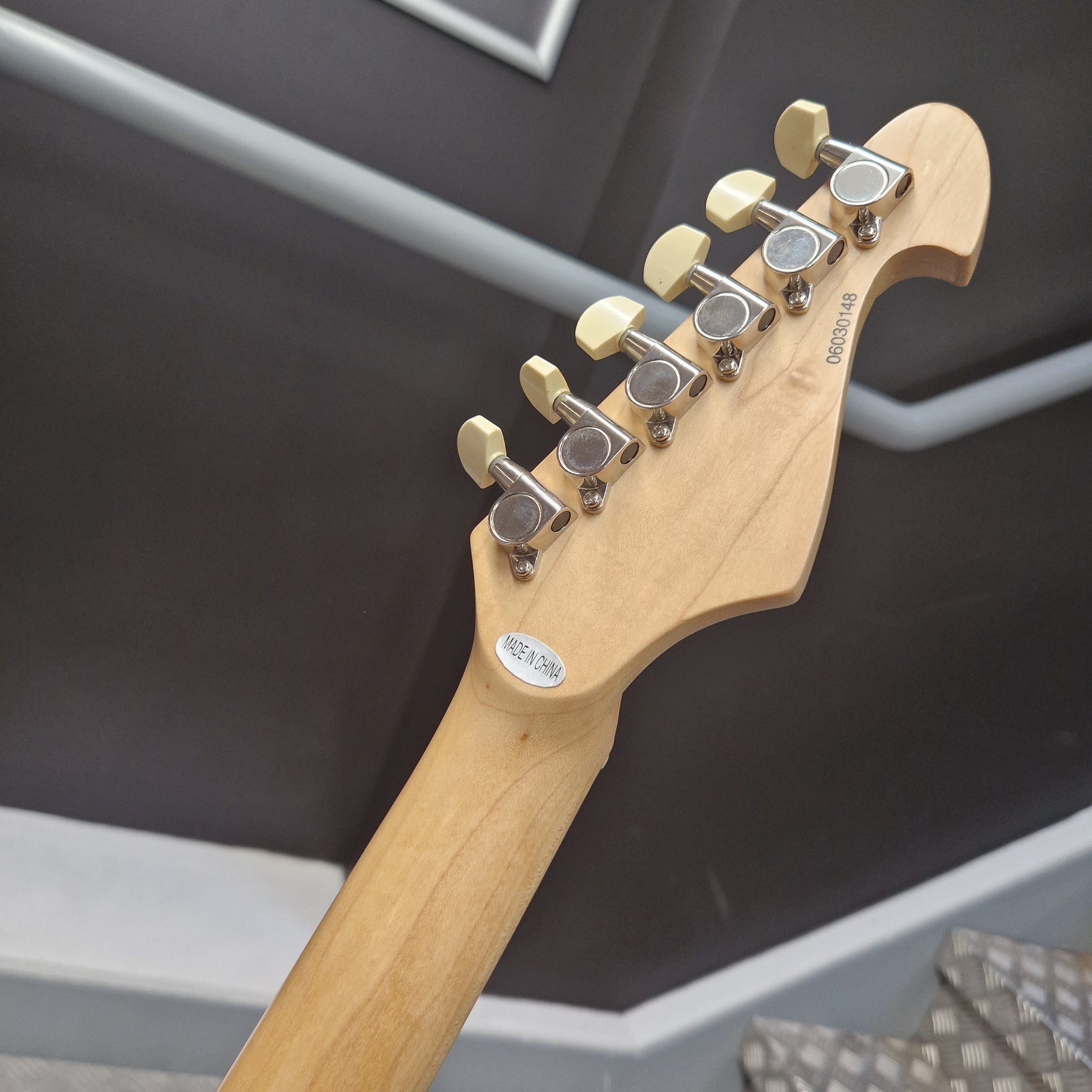 Pre-Owned Lag Close-up of a guitar headstock with tuning pegs on a blurred background