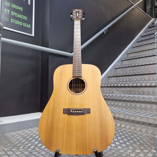 Pre-Owned Cort Acoustic guitar on a stand in a room with soundproofing panels