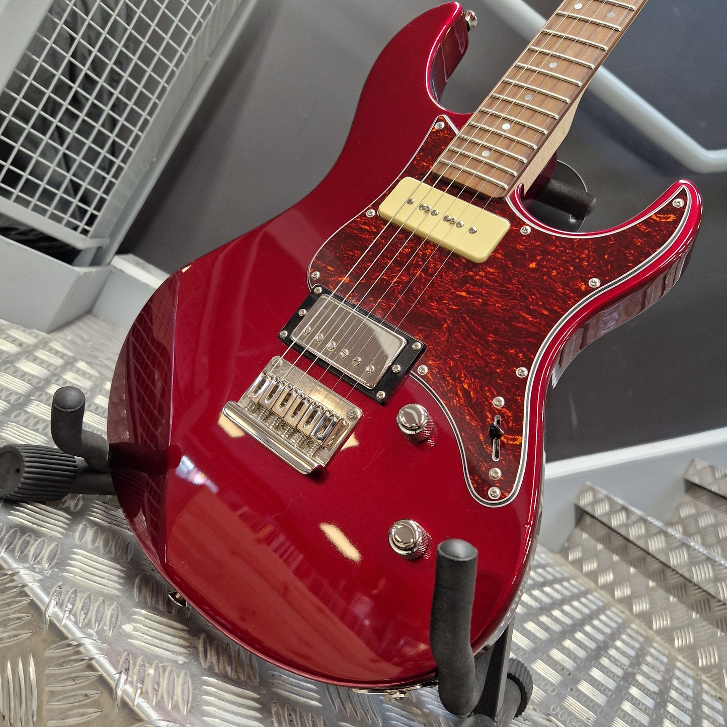 Pre-Owned Yamaha Red electric guitar on a stand with a metallic background