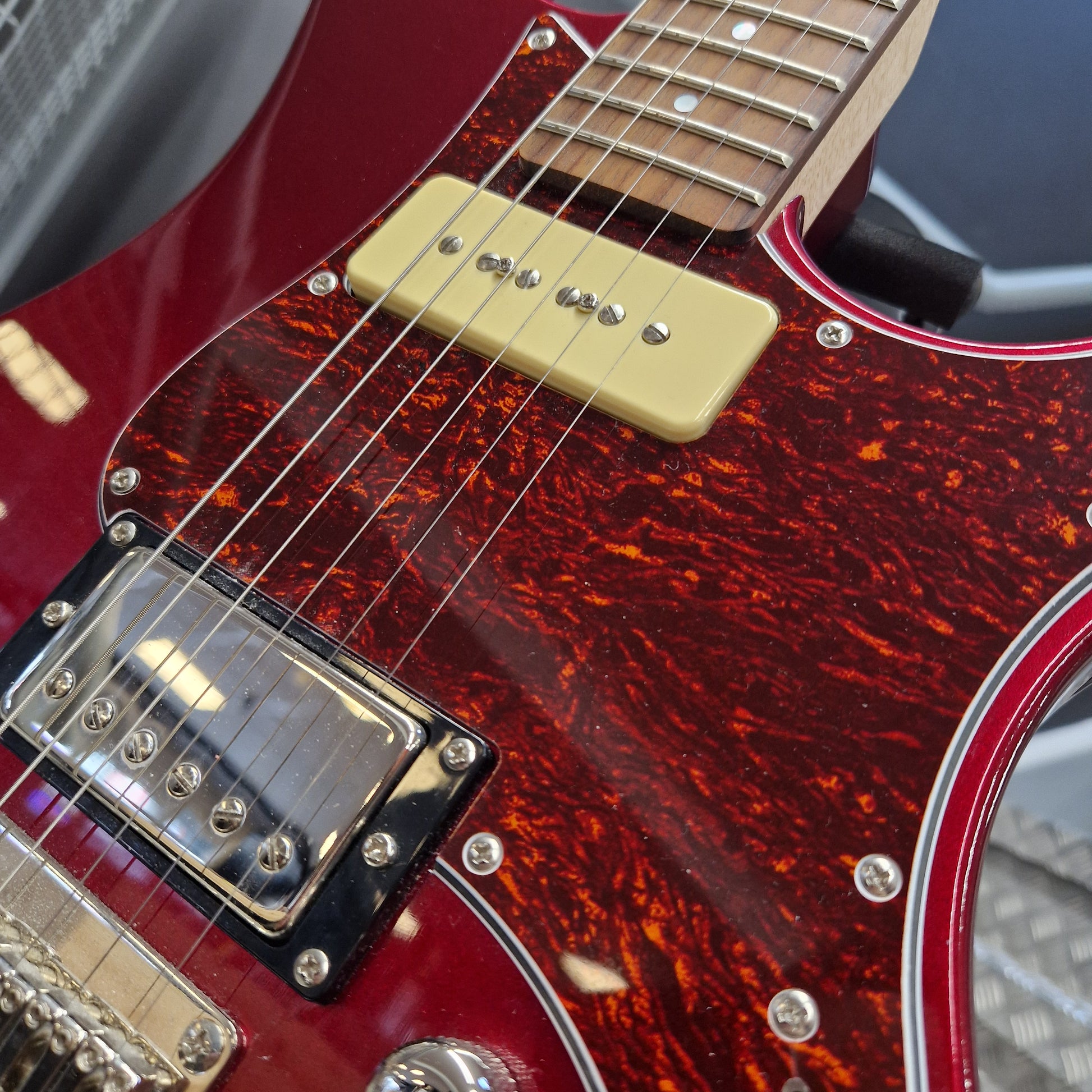 Pre-Owned Yamaha Close-up of a red electric guitar with a tortoiseshell pickguard.