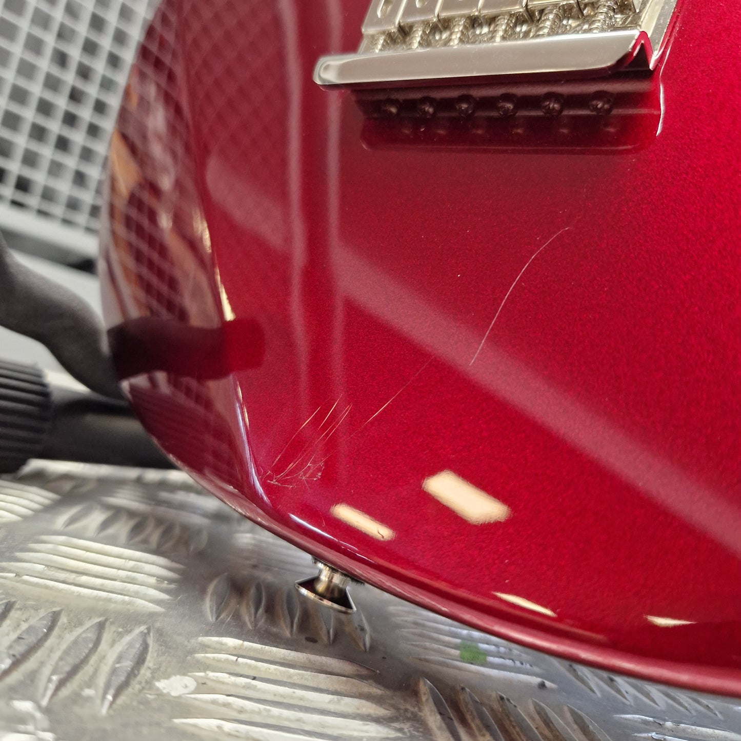 Pre-Owned Yamaha Close-up of a red vehicle's rear bumper with a metallic finish.