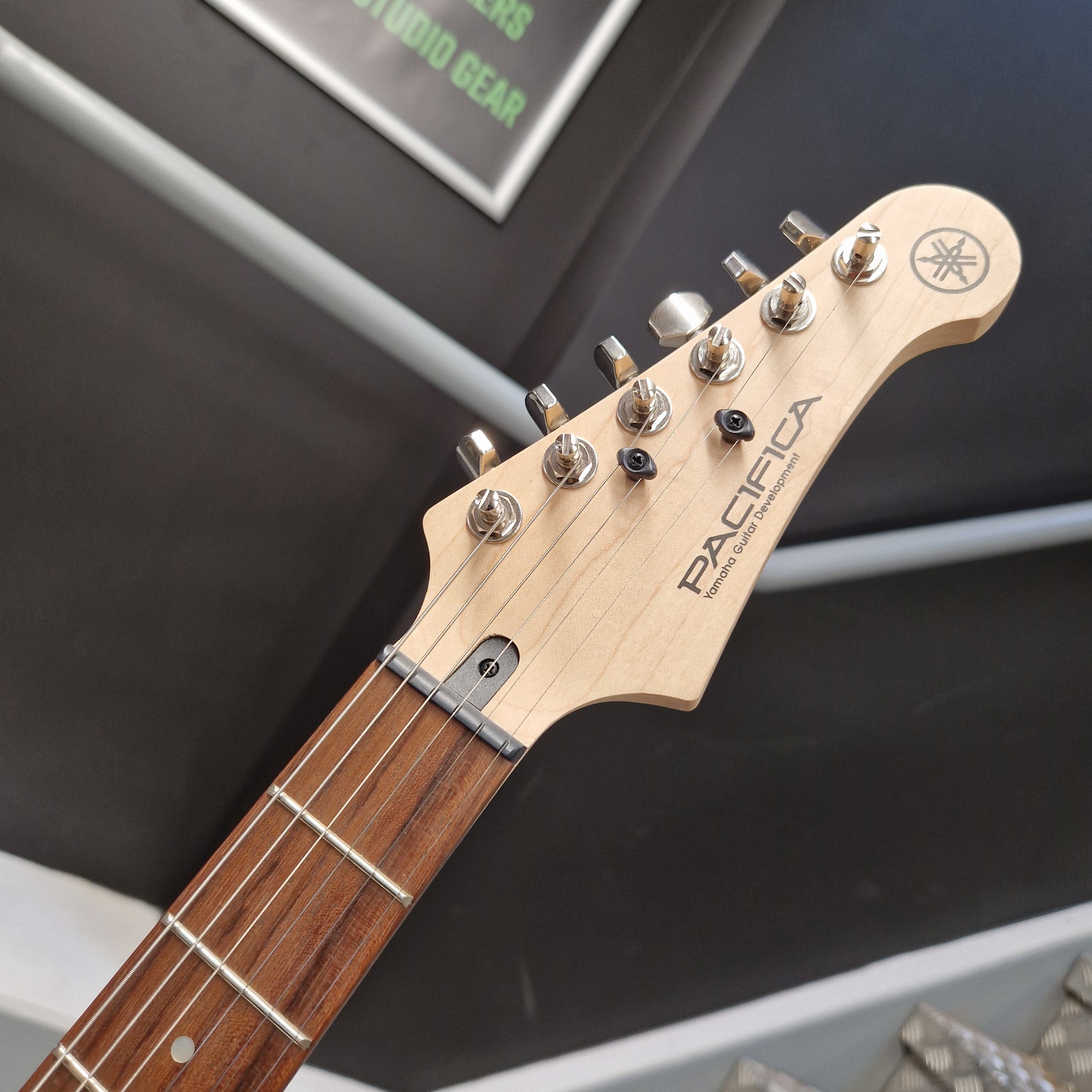 Pre-Owned Yamaha Close-up of a guitar headstock with 'Pacifica' branding on a blurred background