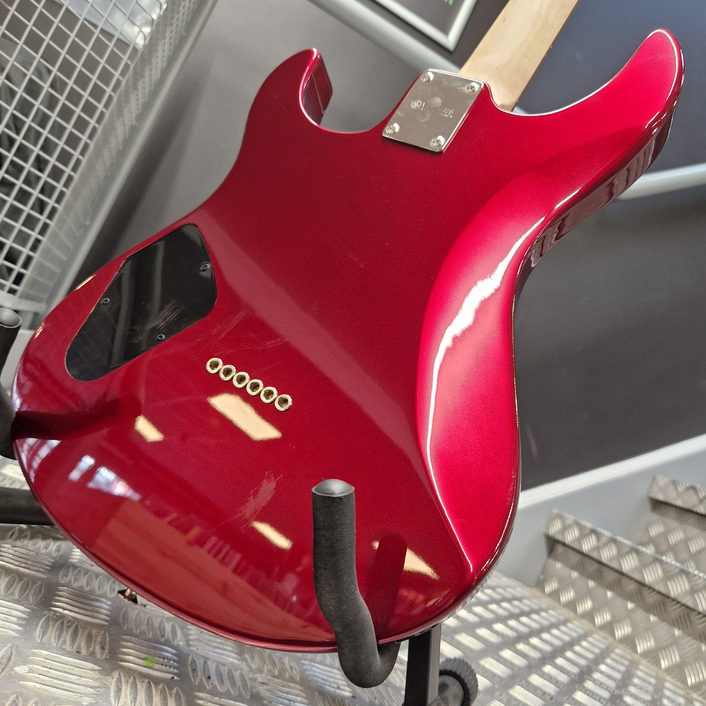 Pre-Owned Yamaha Red electric guitar body on a stand with a metallic background