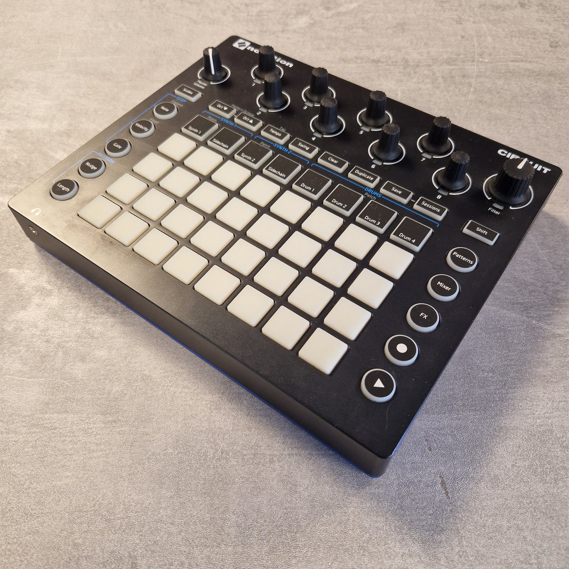 Pre-Owned Novation Music controller with buttons and knobs on a gray surface