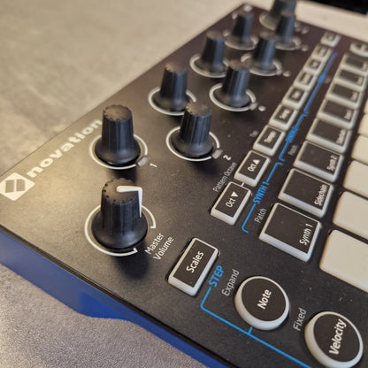 Pre-Owned Novation Close-up of a Velectry electronic music controller with knobs and buttons on a wooden surface.