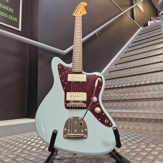 Pre-Owned Squier Classic Vibe 60s  Electric guitar with a light blue body and red pickguard on a stand.