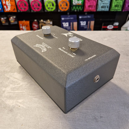 Pre-Owned Dr. Z Trainwreck Guitar effects pedal on a concrete surface with a rack of additional pedals in the background.