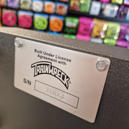 Pre-Owned Dr. Z Trainwreck Metallic label with 'TrailRack' branding on a product with colorful components in the background.