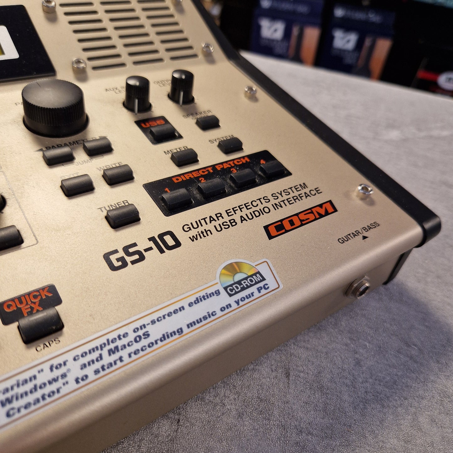 Pre-Owned Boss GS-10 Guitar effects processor with visible brand logos on a gray surface