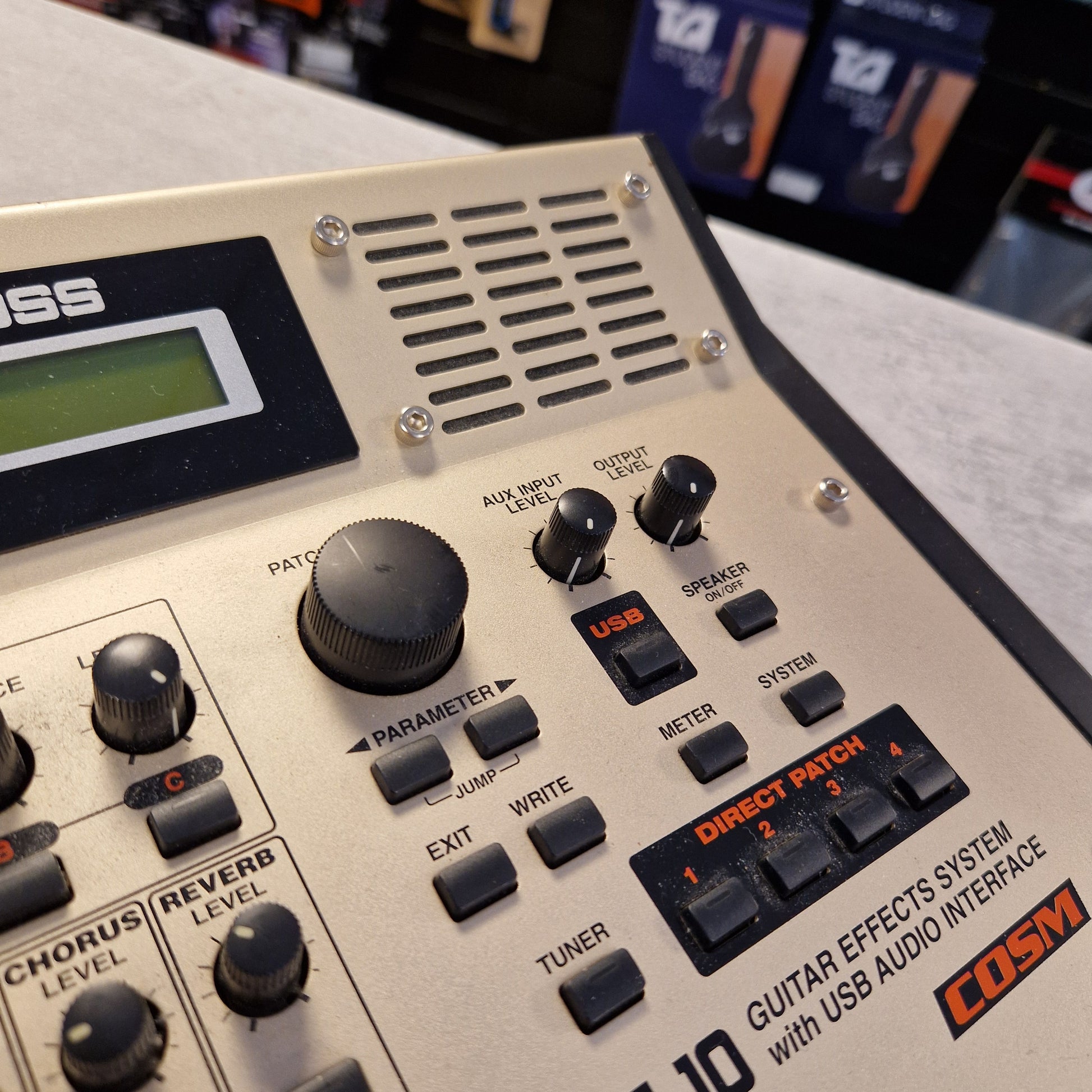 Pre-Owned Boss GS-10 Boss guitar effects processor with control knobs and display on a blurred background