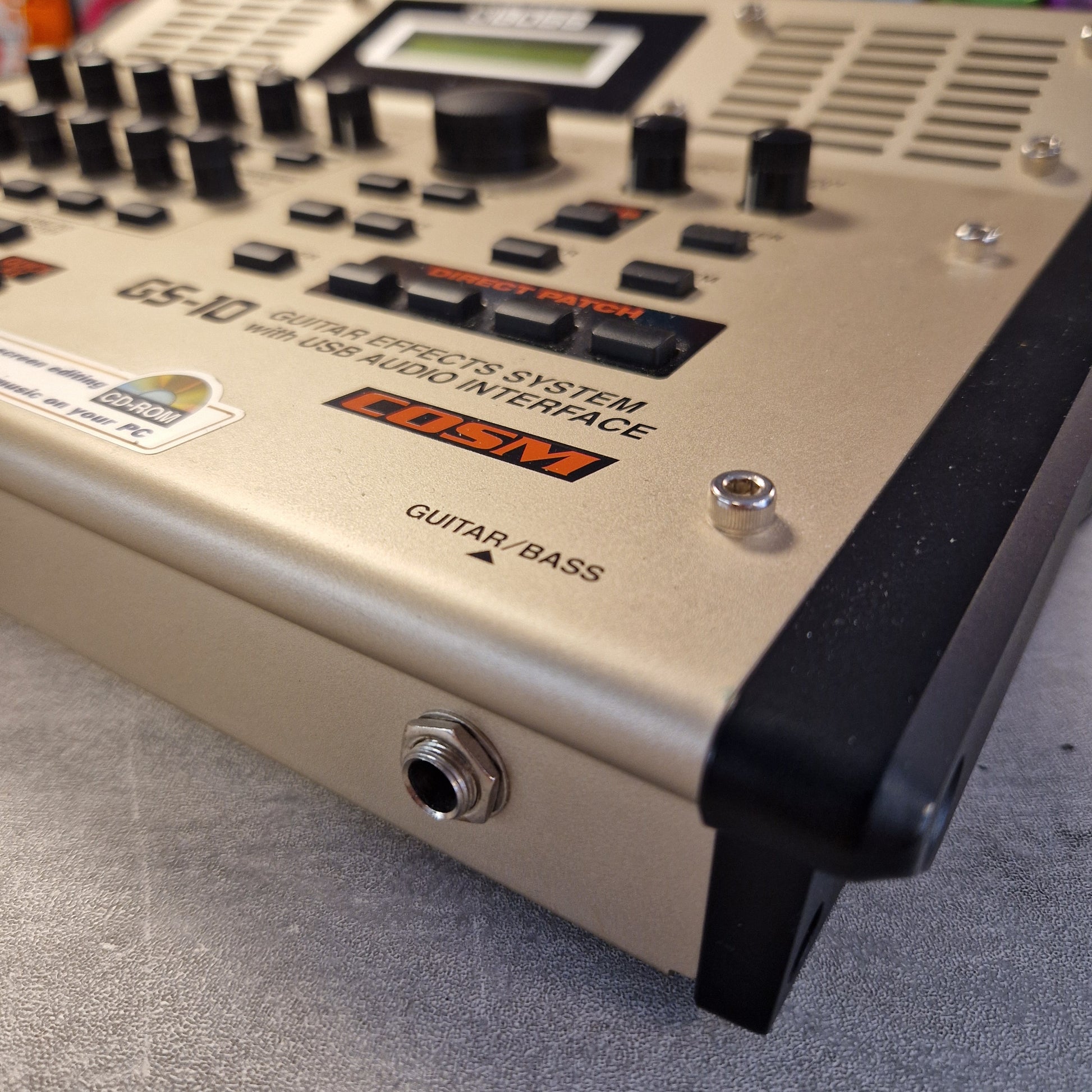 Pre-Owned Boss GS-10 Close-up of a guitar effects pedal with visible brand logos on a gray surface.