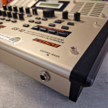 Pre-Owned Boss GS-10 Close-up of a guitar effects pedal with visible brand logos on a gray surface.