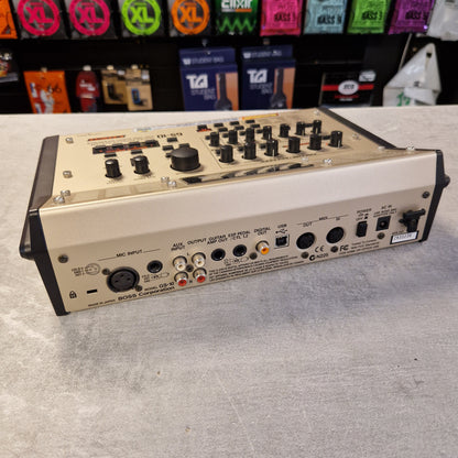 Pre-Owned Boss GS-10 Guitar effects pedal on a gray surface with colorful pedals in the background