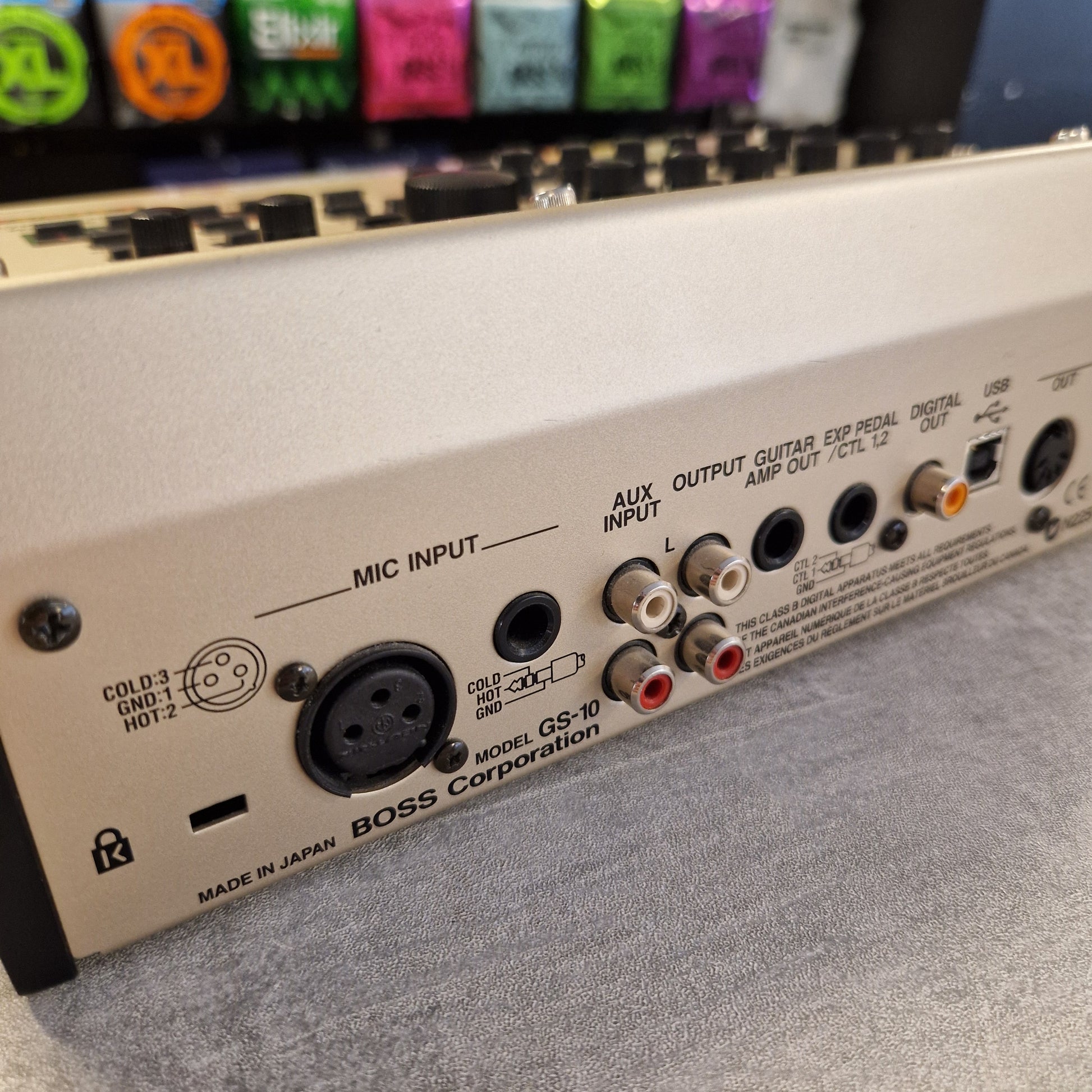 Pre-Owned Boss GS-10 Close-up of an electronic device with various connectors and labels on a gray background.