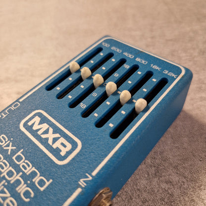 Pre-Owned MXR MX-109 Blue MXR guitar effects pedal with six band graphic equalizer on a textured surface