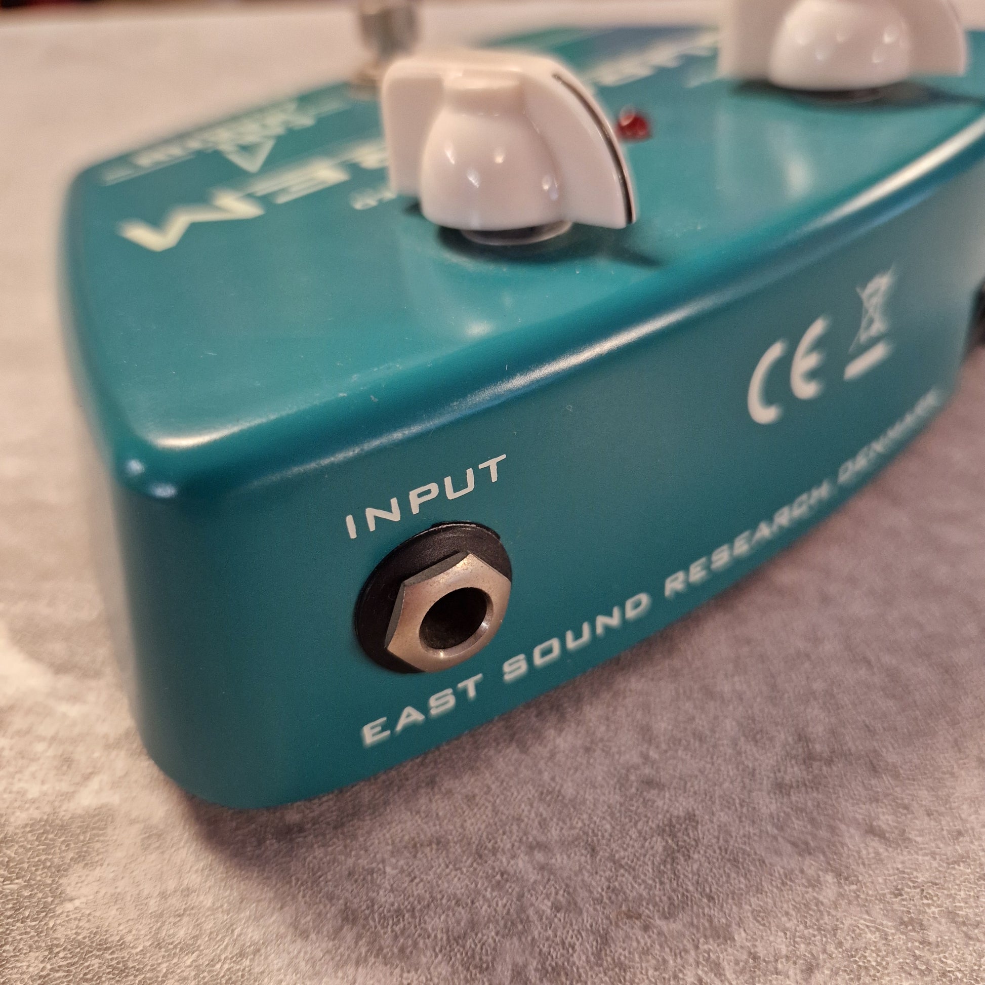 Pre-Owned Carl Martin Surf Trem Turquoise guitar effects pedal with 'Input' and 'East Sound Research' branding on a textured surface.