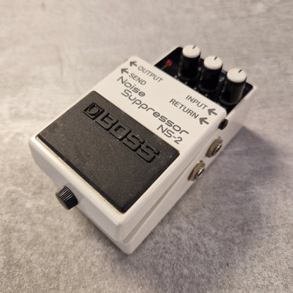 Pre-Owned Boss NS-2 Guitar effects pedal with 'Noise Suppressor NS2' on a textured surface
