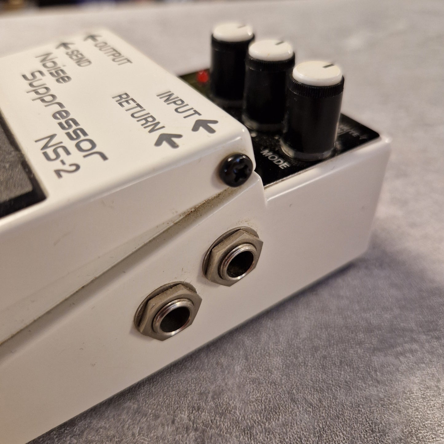 Pre-Owned Boss NS-2 Guitar effects pedal with 'Noise Suppressor NS-2' branding on a textured gray background