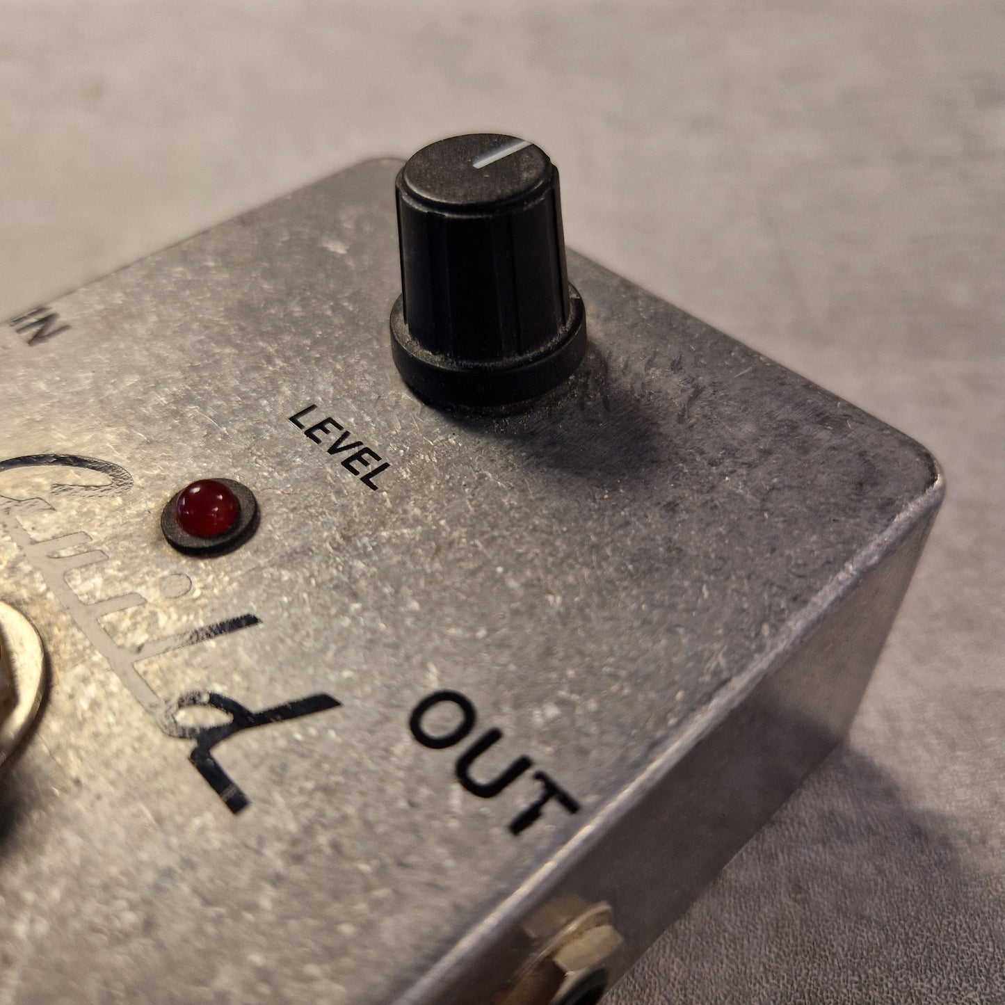 Pre-Owned Guild Brian May Close-up of an electronic device with a level control knob and 'OUT' label on a gray background