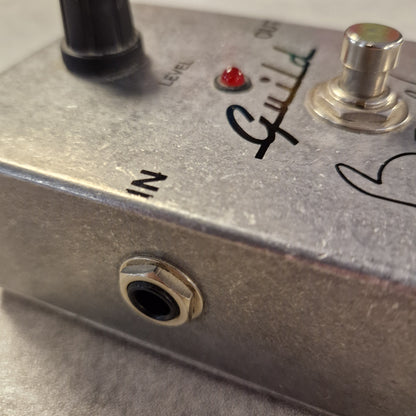Pre-Owned Guild Brian May Close-up of a metallic electronic device with control knobs and labels.
