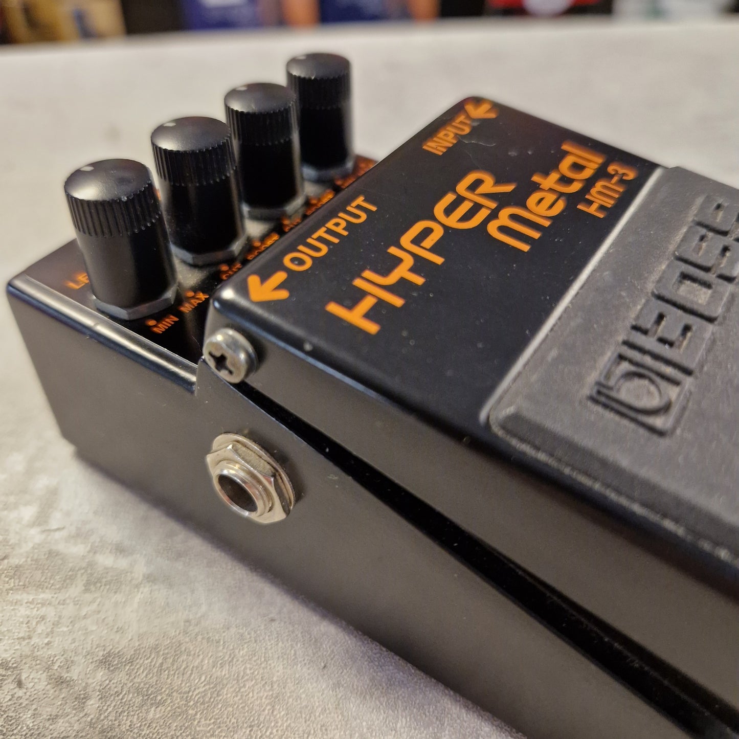 Pre-Owned Boss HM-3 Close-up of a guitar effects pedal with visible branding on a blurred background