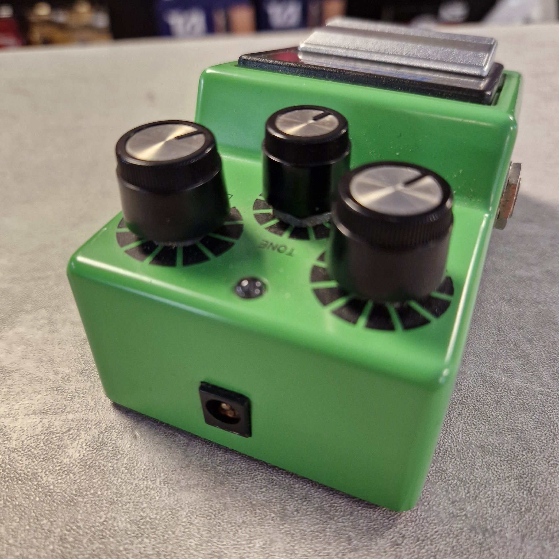 Pre-Owned Ibanez TS9 Green guitar effects pedal with three knobs on a gray surface