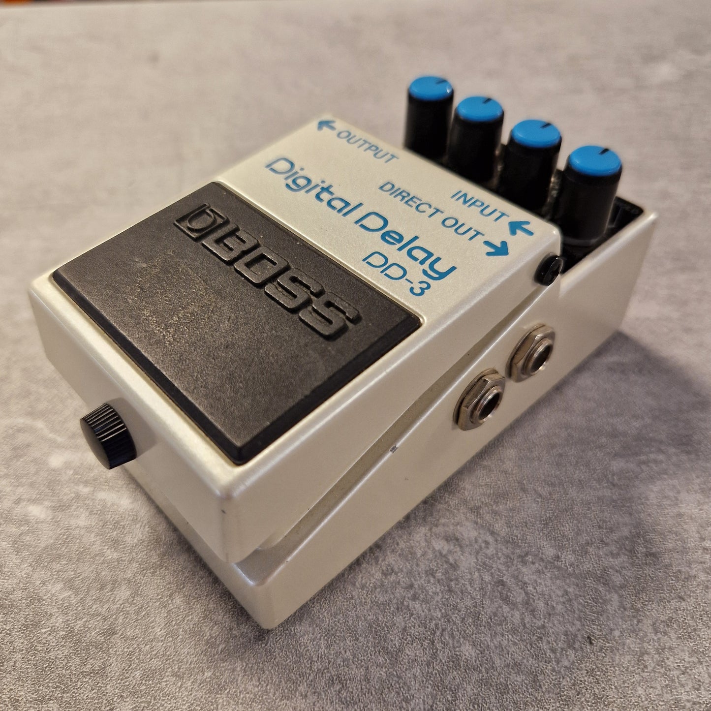 Pre-Owned Boss DD-3 Boss Digital Delay DD-3 guitar effects pedal on a textured surface