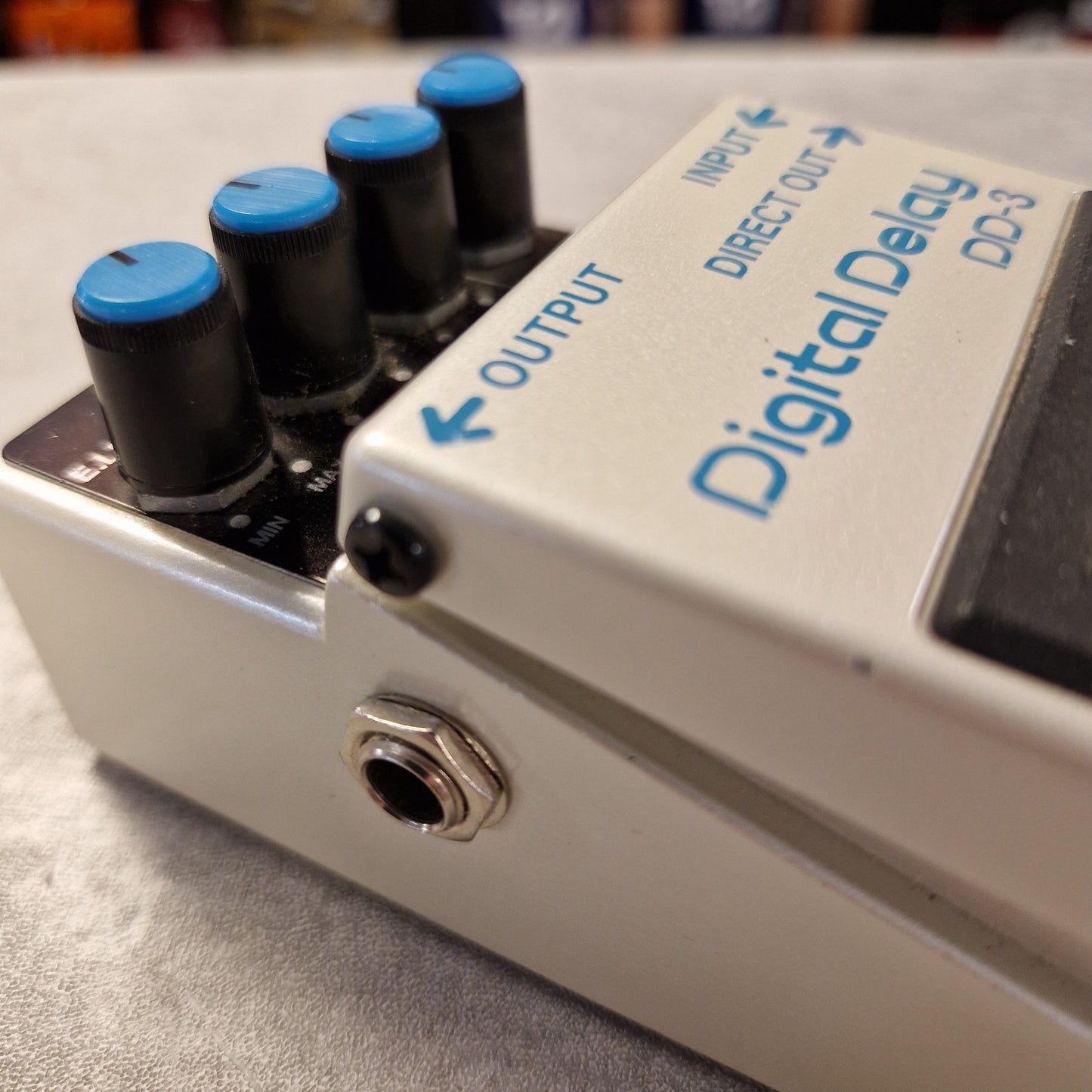 Pre-Owned Boss DD-3 Close-up of a digital delay effects pedal with labeled ports.