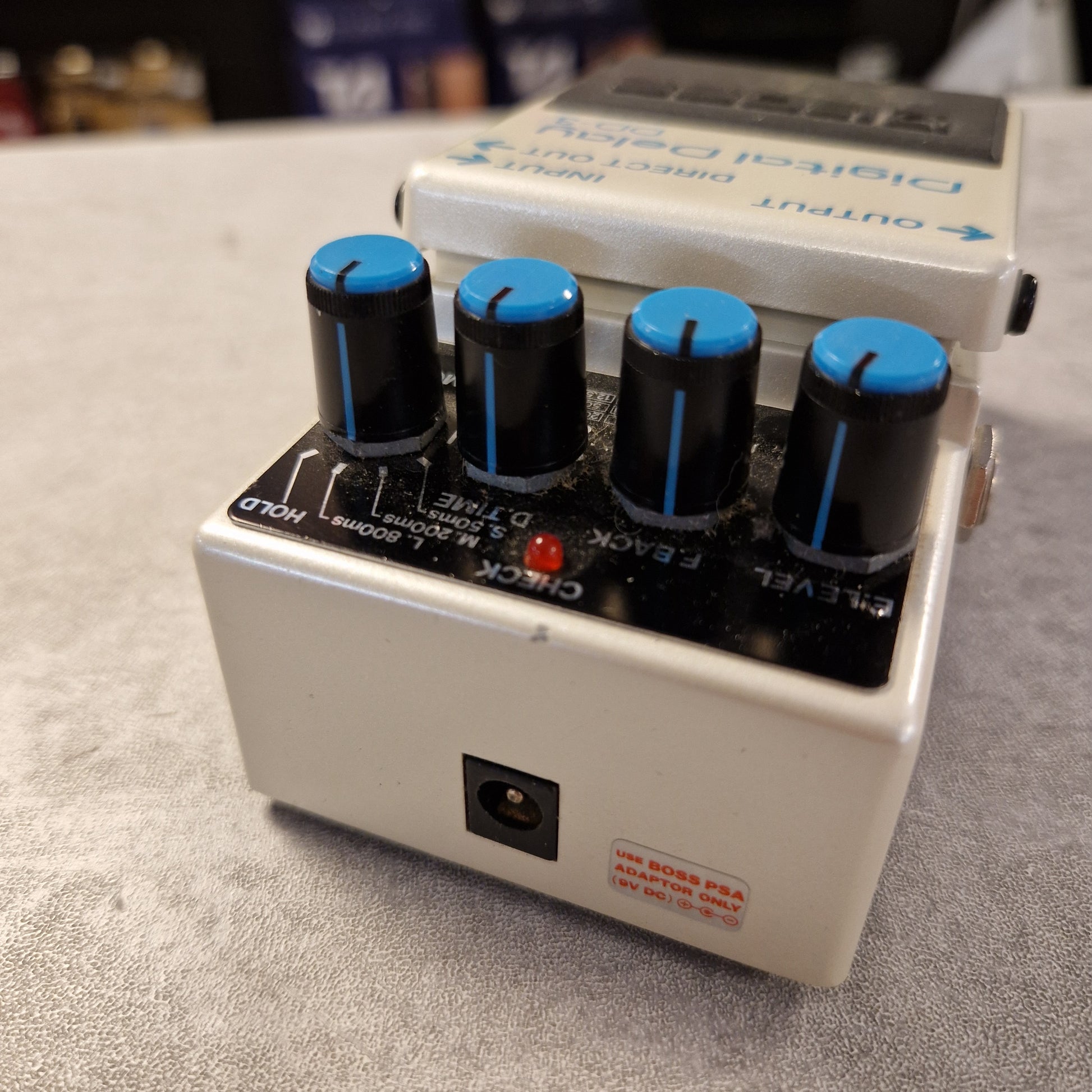 Pre-Owned Boss DD-3 Guitar effects pedal with blue knobs on a gray surface
