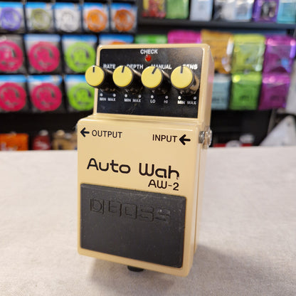 Pre-Owned Boss AW-2 Boss Auto Wah AW-2 guitar effects pedal on a gray surface with a colorful background.