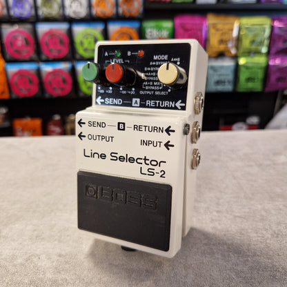Pre-Owned Boss LS-2 Line Selector LS-2 device with colorful equipment in the background