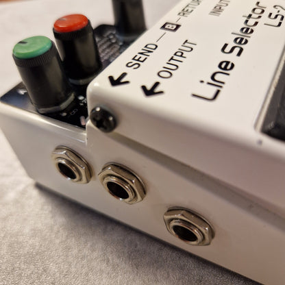 Pre-Owned Boss LS-2 Close-up of a Line Selector audio device with knobs and ports.