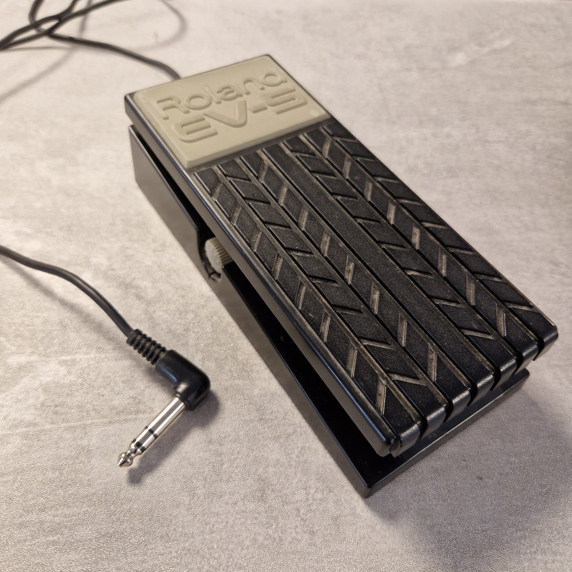 Pre-Owned Roland EV-5 Guitar effects pedal with a cable on a gray surface
