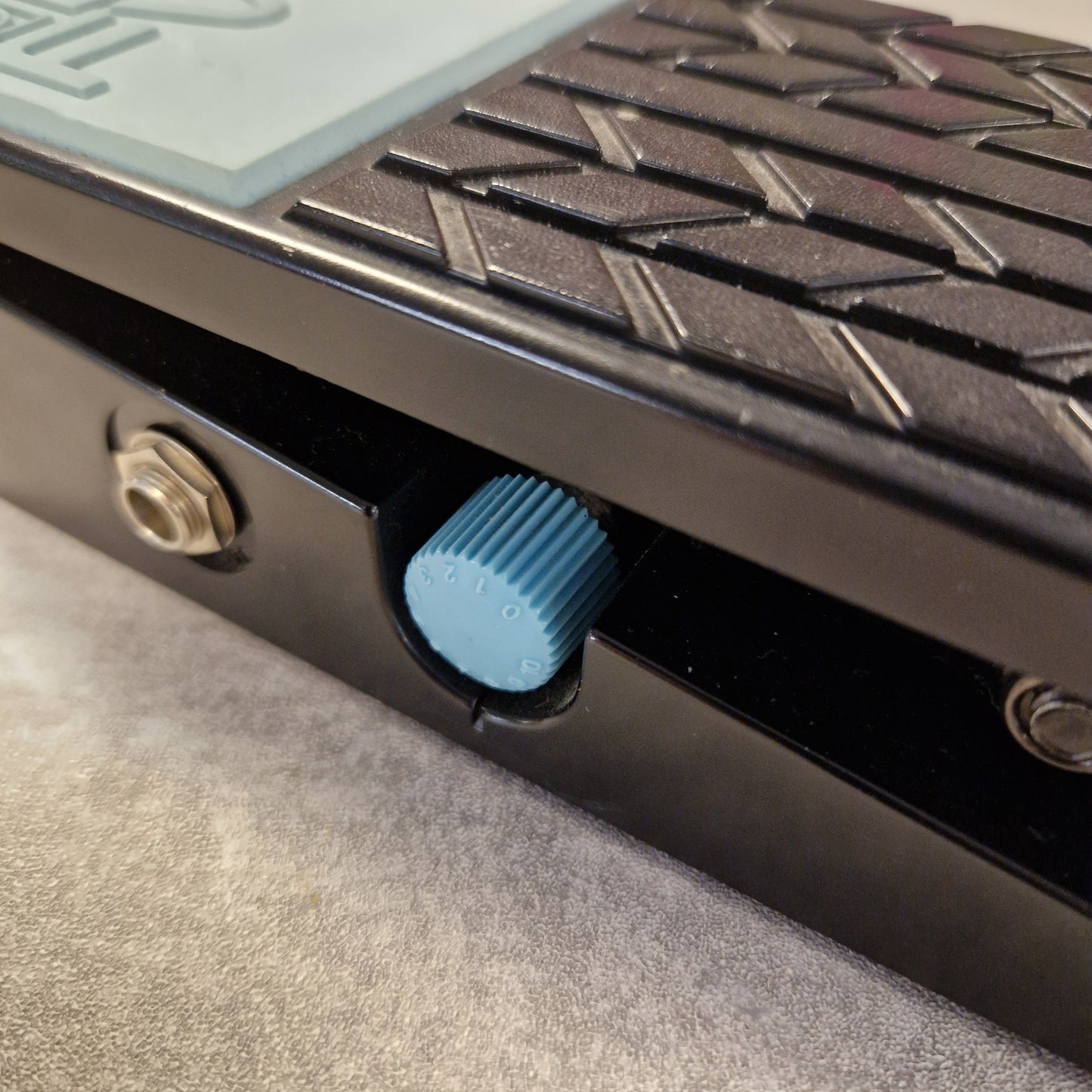 Pre-Owned Boss FV-50H Close-up of a textured surface with a blue knob and metallic elements.