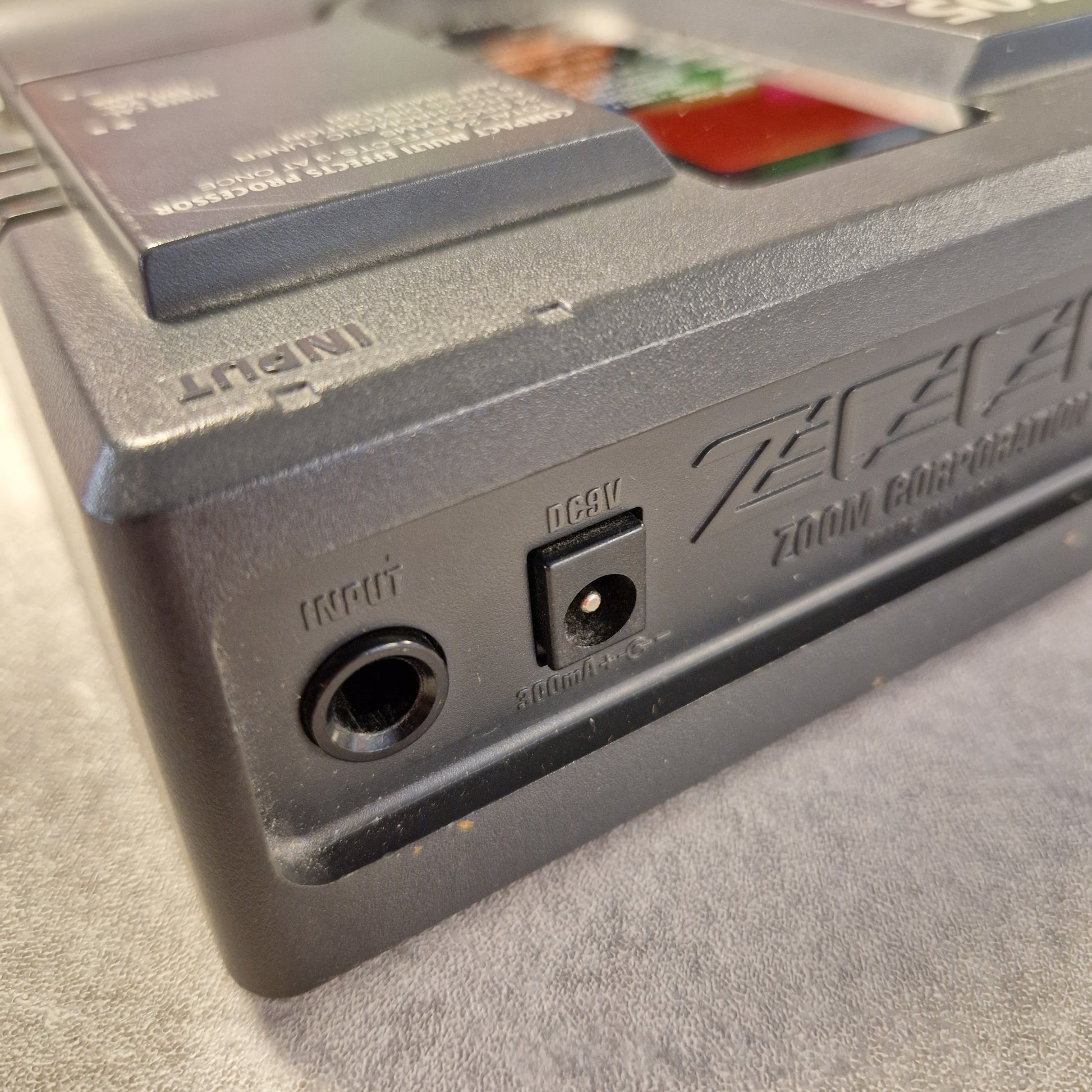 Pre-Owned Zoom 505 Close-up of a cassette tape with visible branding on a textured surface.