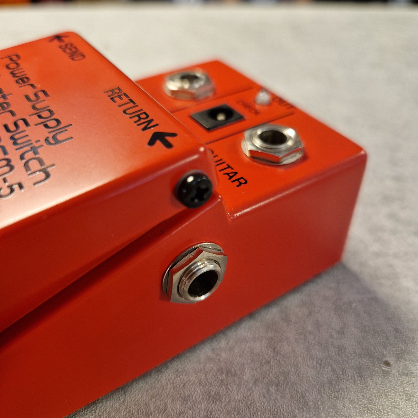 Pre-Owned Boss PSM-5 Red electrical switch with 'RETURN' and 'Power Supply Master Switch' labels on a gray background
