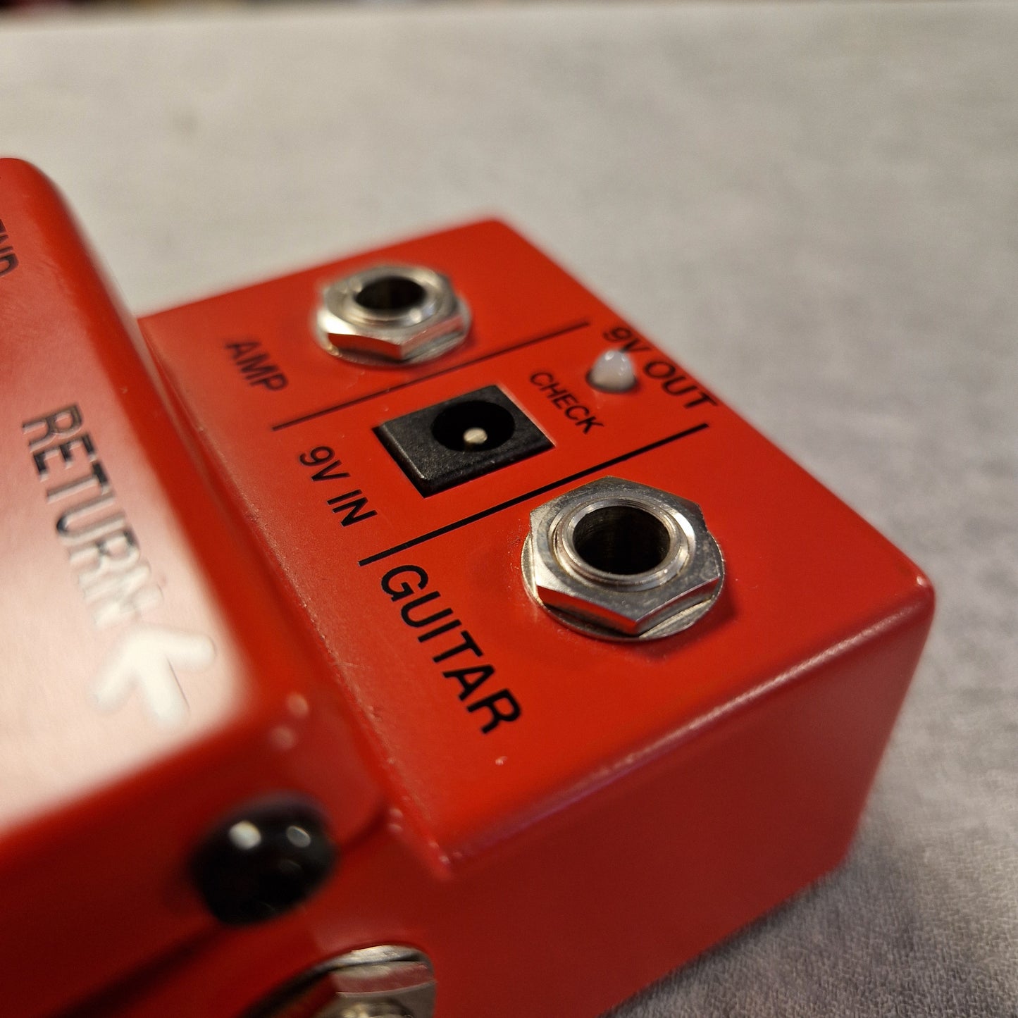 Pre-Owned Boss PSM-5  Close-up of a red guitar effects pedal with electrical connections.