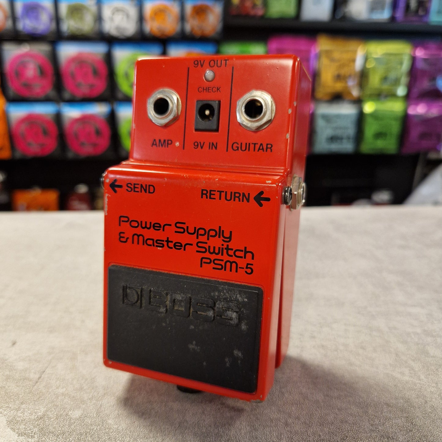 Pre-Owned Boss PSM-5 Red power supply and master switch pedal with visible branding on a textured surface.