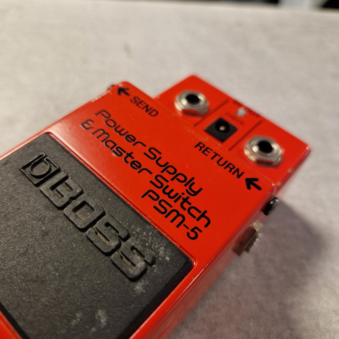 Pre-Owned Boss PSM-5 Red and black power supply switch labeled 'PSM-5' with Boss branding on a gray background