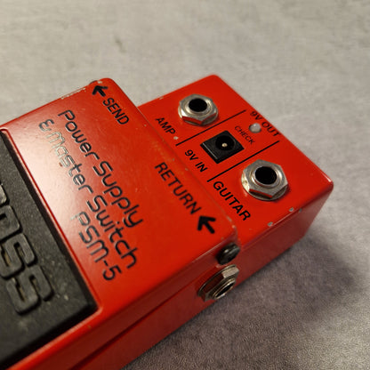 Pre-Owned Boss PSM-5 Red power supply switch pedal with labeled ports on a gray background