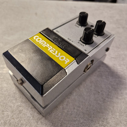 Pre-Owned Tokai TCO-1 Compressor pedal with a yellow label on a gray surface