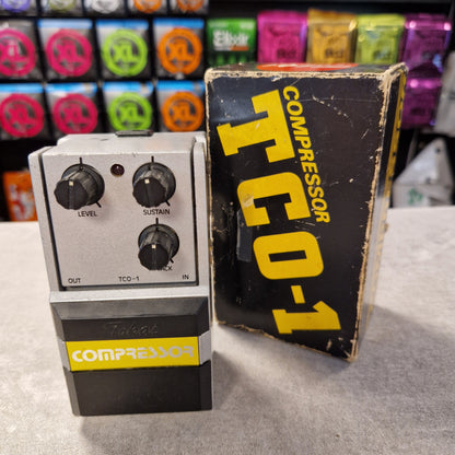 Pre-Owned Tokai TCO-1 Compressor TCO-1 pedal with packaging on a gray surface