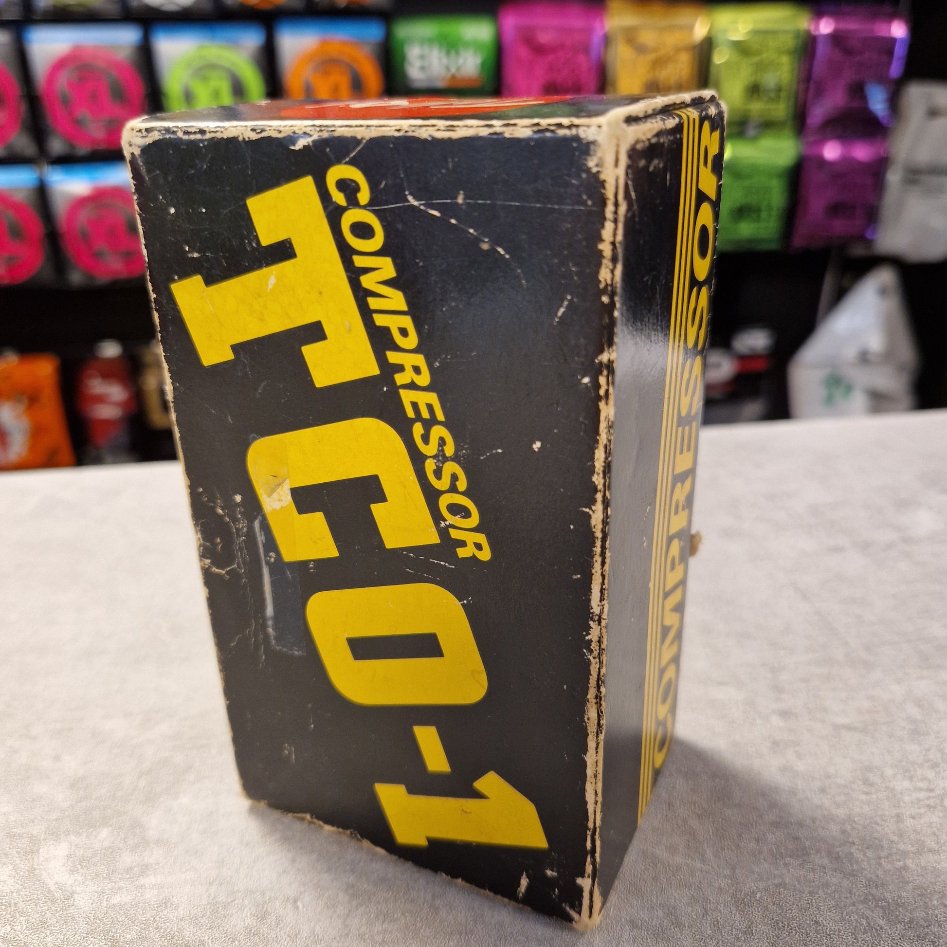 Pre-Owned Tokai TCO-1 Vintage compressor TCO-1 box with colorful items in the background