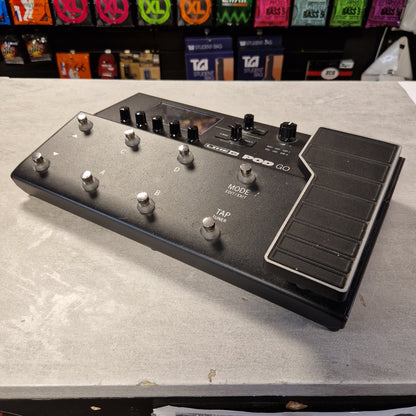 Pre-Owned Line 6 POD Go Guitar effects pedal on a gray surface with colorful pedals in the background